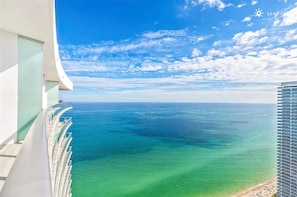 Ein modernes Gebäude mit einem geschwungenen Balkon mit Blick auf ein klares, blaues Meer.