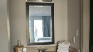 A bathroom with a sink, mirror, and towel rack. - My Home and Suites Covington (Covington)
