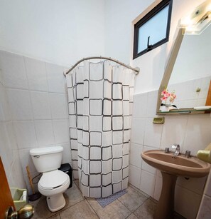 A bathroom with a toilet, a sink, and a shower curtain with a geometric pattern. - Peace and comfort near Oaxaca (Tlalixtac de Cabrera)