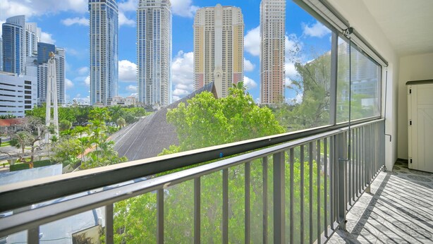 Un balcón con vistas a edificios altos y árboles.