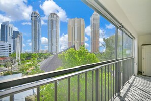 Un balcone con vista su edifici alti e alberi.