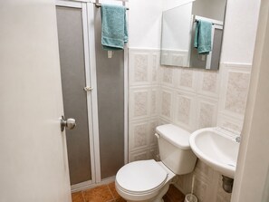 A bathroom with a toilet, sink, and a shower with a glass door. - Apartment for 4 people (Cartagena de Indias)