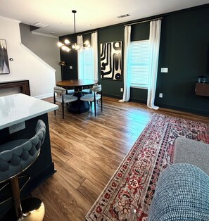Eine moderne Küche mit Essbereich, Holzboden und einem großen Teppich.