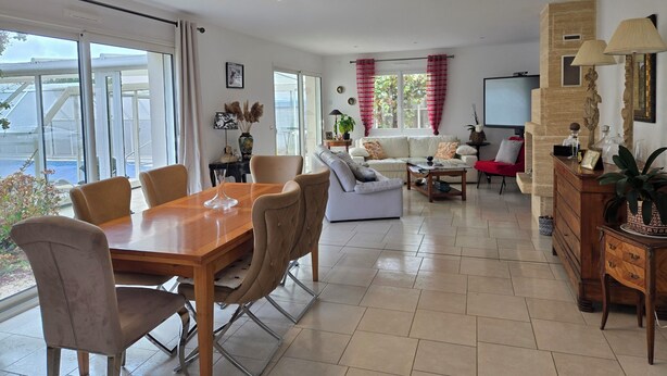 Un vaste espace de vie comprenant une table à manger, un canapé et une vue sur l’extérieur.