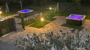 A hot tub area with two hot tubs, a fence, and a pathway. - Apartment Casa Sossa 2 (Umag)