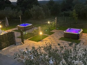 A hot tub area with two hot tubs, a fence, and a pathway. - Apartment Casa Sossa 2 (Umag)