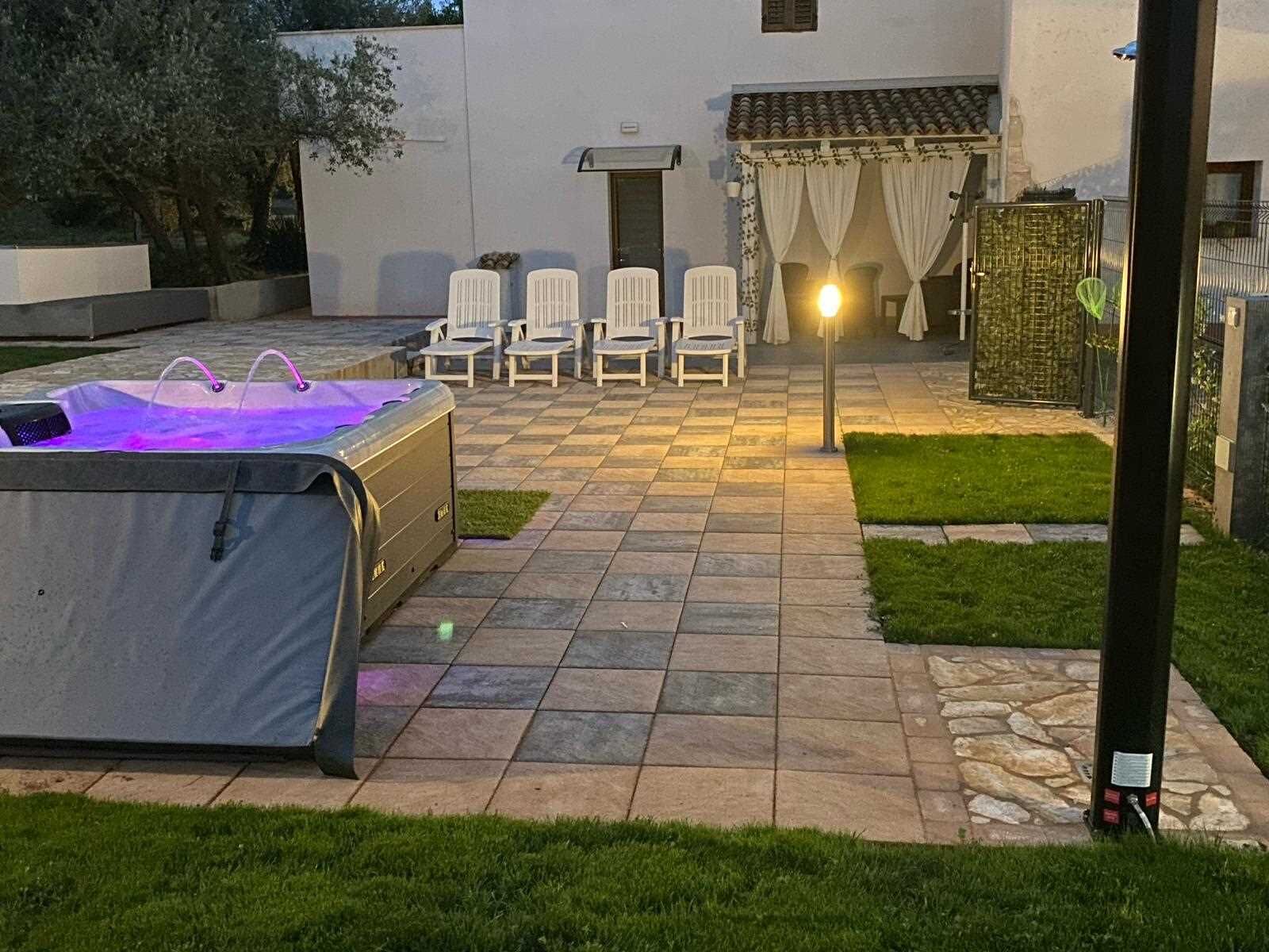 A patio area with a pool heater, outdoor chairs, and a pergola with curtains.