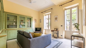 A living room with a sofa, television, green cabinets, and a sewing machine. - Zisa Gardens of Palermo (PALERMO)