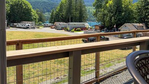 A campground with RVs, a fenced area, and a mountain backdrop. - Lake Sutherland Tiny Home, Heaven (Port Angeles)