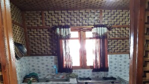 Una cocina compacta con baldosas estampadas, un fregadero, una estufa y una ventana con cortinas.