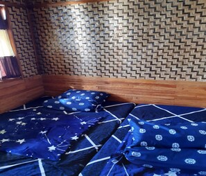 Ein Zimmer mit einer Holzwand und einem Bett mit blauer Bettwäsche.