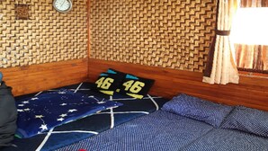 Una habitación con una pared estampada, una cama con manta de diseño de estrellas, un reloj y una ventana con cortinas.