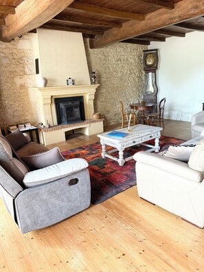 A cozy living room with a fireplace, stone walls, and wooden beams. - A spacious house, perfect for a large family or a trip with friends, located 15 km from the ocean (Trizay)