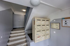A staircase with a beige mailroom and a bulletin board on the wall. - Fabregas - Climatisation - Terrasse (La Seyne-sur-Mer)