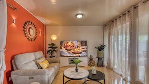 Ein Wohnzimmer mit einer Couch, einem Couchtisch, einem Fernseher und einem Kamin.