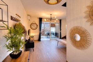 Ein stilvoller Wohnbereich mit Blumentopf, Wanduhr und Essbereich mit Tisch und Stühlen.