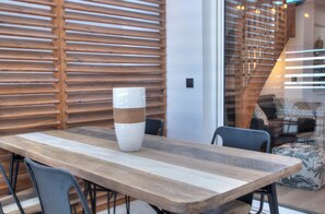 Ein Holzespeisesaal mit Stühlen, einer hohen Vase und einer Wand aus Holzlatten.