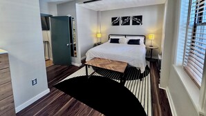 A modern bedroom with a bed, bedside lamps, and a view of the outside through a window. - Family-friendly 4-bedroom apartment in the historic North End of Boston (Boston)