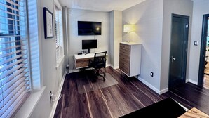 A modern room with a desk, chair, TV, and a lamp. - Family-friendly 4-bedroom apartment in the historic North End of Boston (Boston)