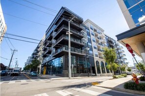 A multi-story building with balconies, large windows, and a stop sign. - 1BR w/ Balcony Steps to Broadway Nashville (Nashville)