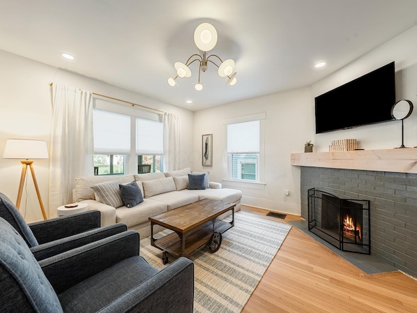 A modern living room with a sofa, coffee table, and fireplace.