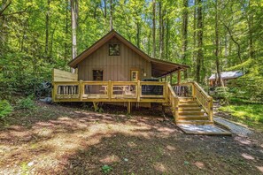 Een chalet met terras, trap en raam.