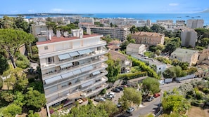 Un hôtel à plusieurs étages doté de balcons, d’un parking et offrant une vue sur la mer et le paysage urbain.