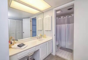 A bathroom with a double sink, a large mirror, a shower curtain, and a towel rack. - Soulside 5G by Mira-Mar (Wrightsville Beach)