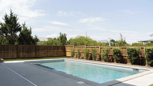 A rectangular swimming pool with a wooden deck and a wooden fence in the background. - 13 Raleigh- Ocean views, Private Pool and more (Wrightsville Beach)