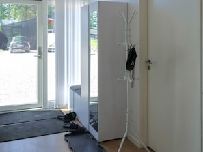 Ein Zimmer mit einer Schiebeglasdoor zum Parkplatz, einem Kleiderständer und einer Bank.
