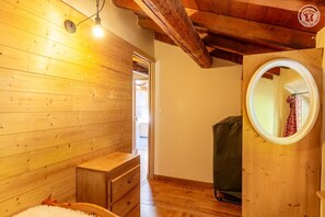 En inredning med träpanel, ett träskåp, en spegel och en lampa.