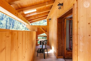 Eine Holzhütte mit Essbereich, Tisch und Stühlen.
