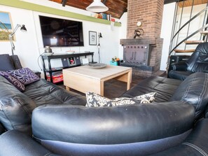 Ein Wohnzimmer mit einer Couch, einem Couchtisch, einem Kamin und einem Fernseher.