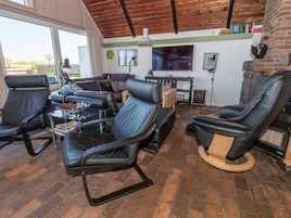 Una sala de estar moderna con sofás de cuero, una mesa de centro, una chimenea y un televisor.
