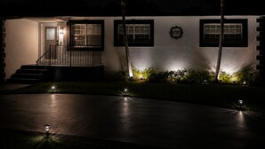 A modern house with a well-lit entrance, a visible number '1751' on the wall, and a paved driveway. - Signature Stay 5 Minutes From Hard Rock Stadium (Miami Gardens)