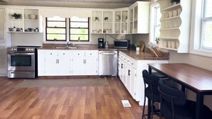 A kitchen with white cabinetry, a stainless steel stove, a dishwasher, and a wooden countertop. - River Edge Retreat - Private Waterfront & Fire Pit (Jacksonville)