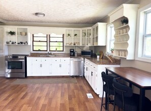 A kitchen with white cabinetry, a stainless steel stove, a dishwasher, and a wooden countertop. - River Edge Retreat - Private Waterfront & Fire Pit (Jacksonville)