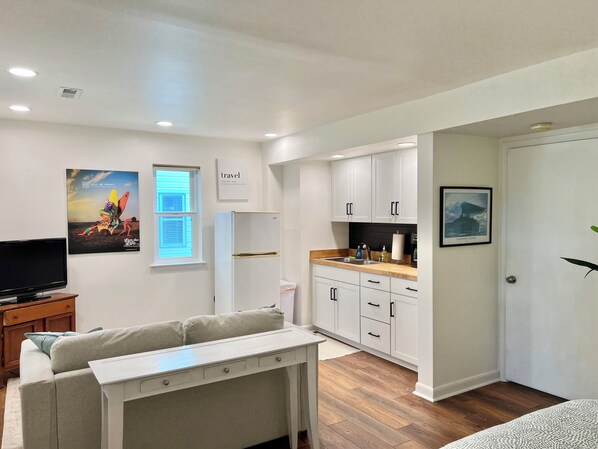 Eine moderne Wohnung mit Wohnzimmer, Küchenzeile und Essbereich.