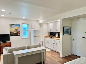 Un appartement moderne comprenant un salon, une kitchenette et un coin repas.