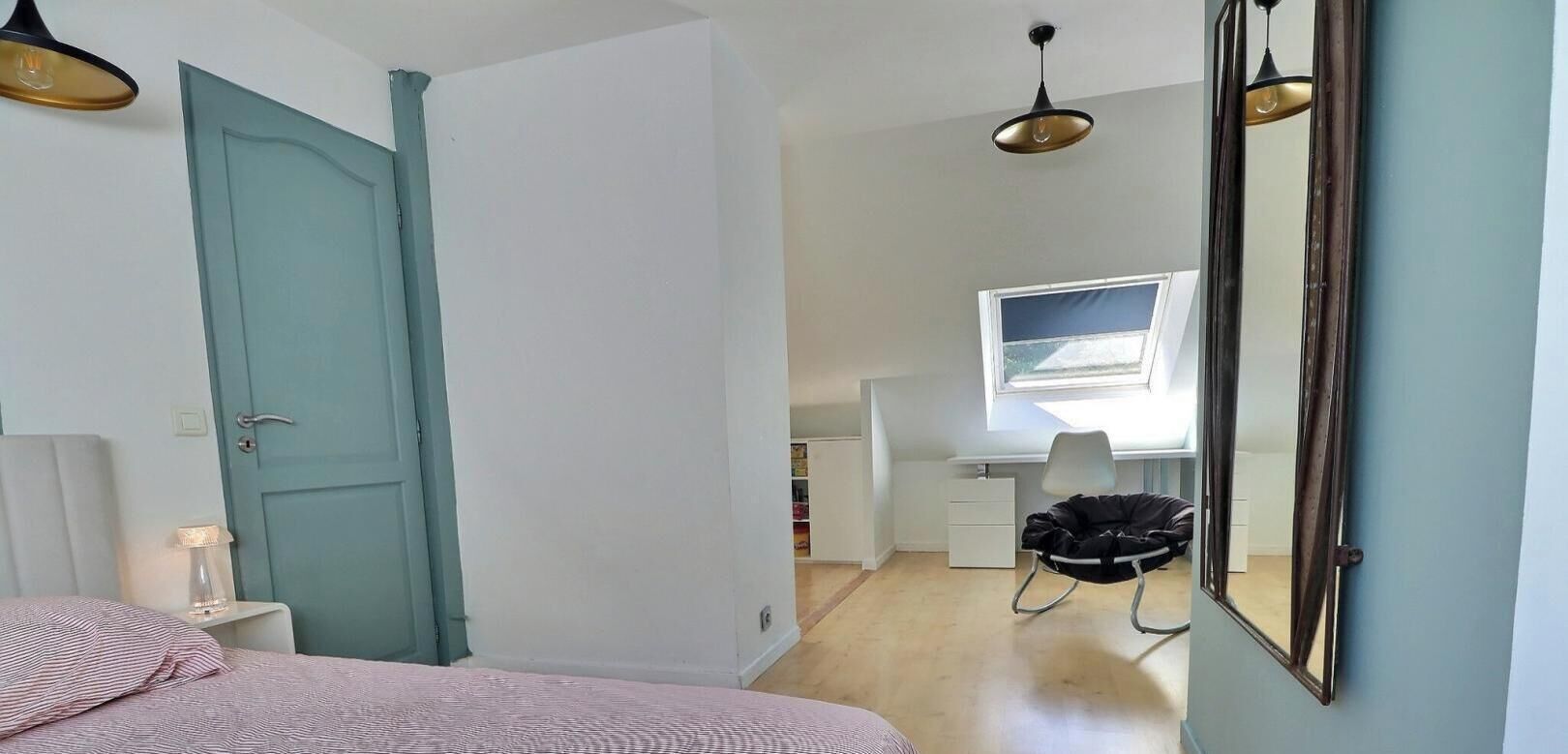 Un dormitorio con cama, escritorio, silla y puerta.