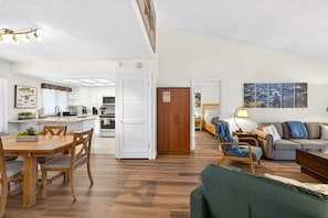 A modern apartment with a dining area, kitchen, and living room.