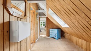 Ein schmaler Korridor mit Holzwänden und einer schrägen Decke.
