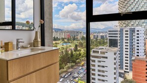 Un baño moderno con un ventanal grande, un lavabo y un espejo.