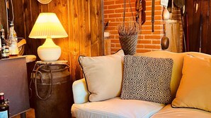 Ein gemütliches Zimmer mit einer Holzwand, einem weißen Sofa, einer Lampe und verschiedenen Dekorationselementen.