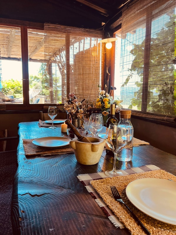 A dining table set with plates, cutlery, a wine glass, a candle, and a mortar and pestle.
