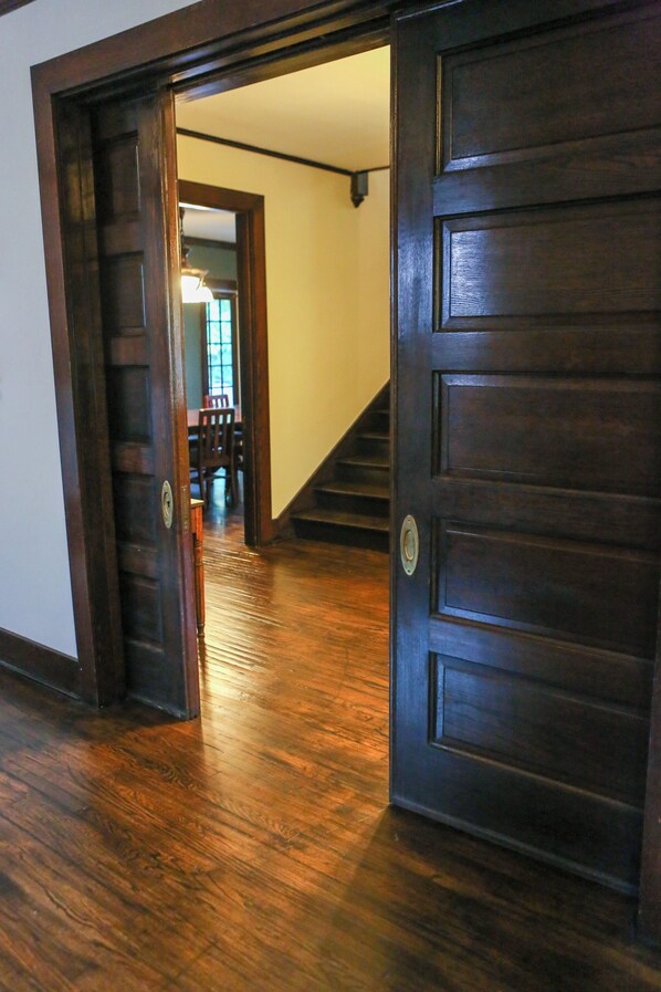 A wooden door leading to a staircase and a dining area.