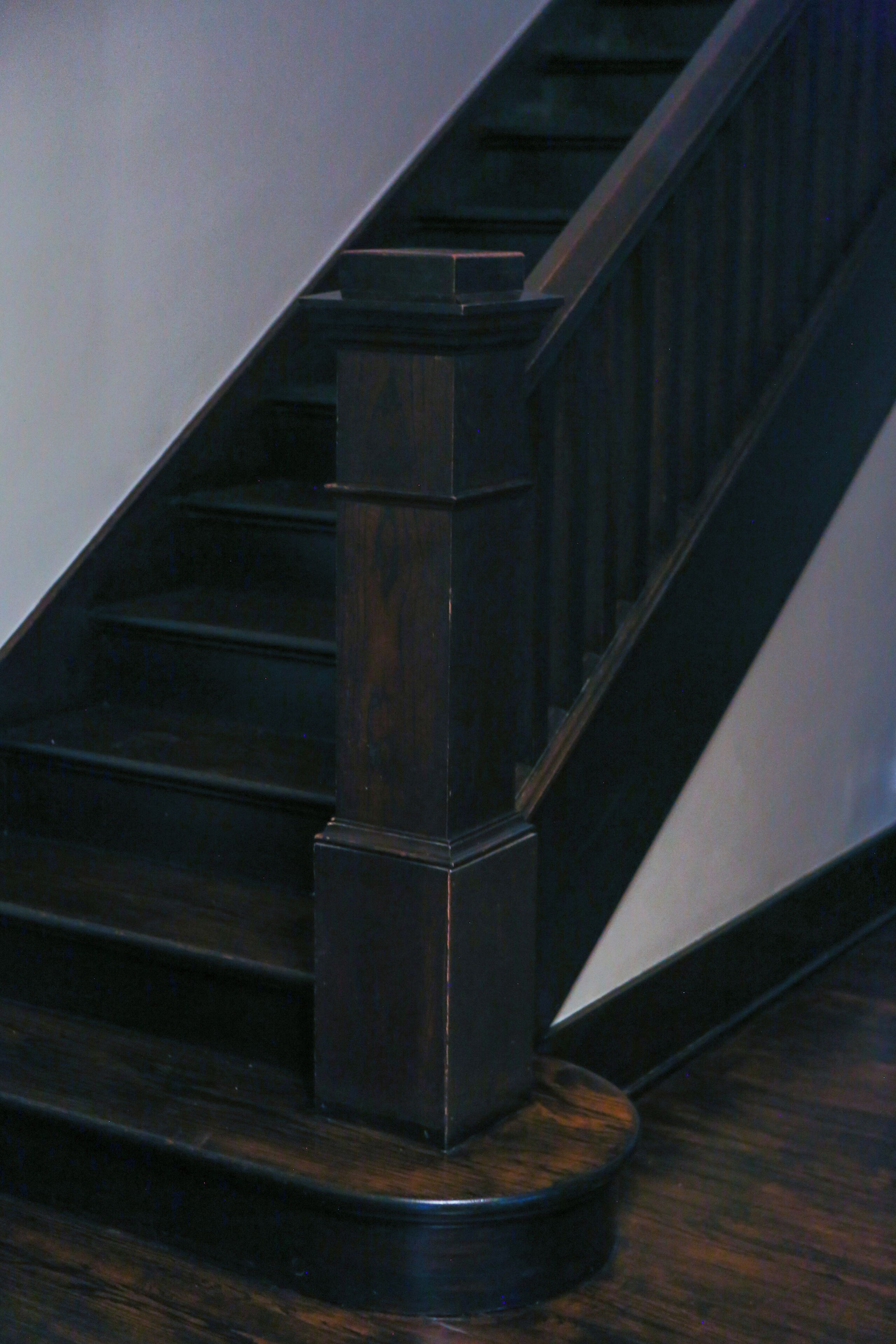 A staircase with dark wood steps and a handrail.