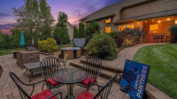 Een terras met buitenmeubilair, een jacuzzi en een barbecue.
