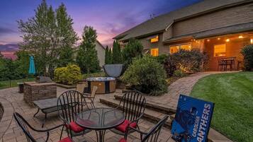 Une terrasse avec mobilier d’extérieur, un jacuzzi et un barbecue.