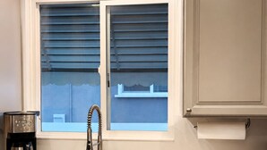 Eine Küche mit Fenster, Spüle und Kaffeemaschine.